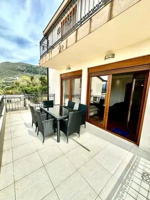 a patio with a table and chairs on a balcony at Villa Sun in Kotor