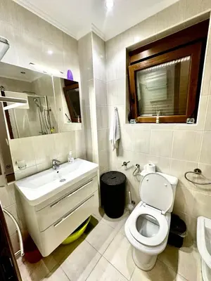 a bathroom with a white toilet and a sink at Villa Sun in Kotor