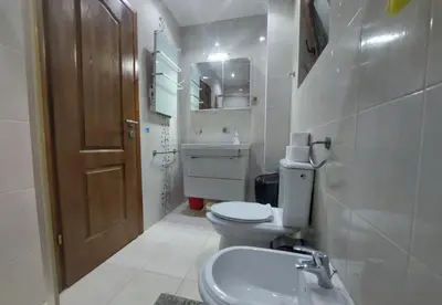 a white bathroom with a toilet and a sink at Villa Sun in Kotor