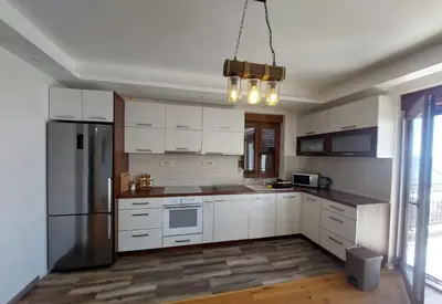 a kitchen with white cabinets and a stainless steel refrigerator at Villa Sun in Kotor