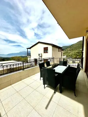 a patio with a table and chairs on a balcony at Villa Sun in Kotor