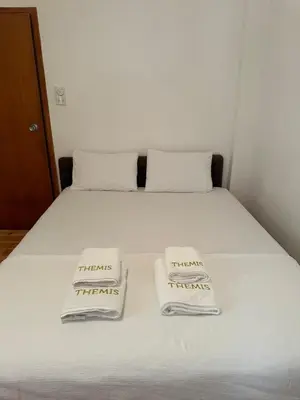 a bed with two towels on top of it at Themis Apartment in Kotor