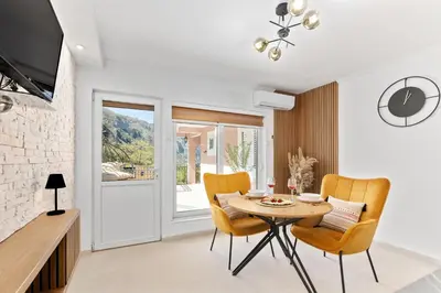 a dining room with a table and yellow chairs at Apartment Petar 1 in Kotor
