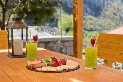 a table with a plate of food and two glasses of juice at Apartment Petar 1 in Kotor