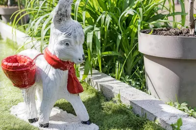 a statue of a white dog holding a red bucket at Apartment Petar 1 in Kotor