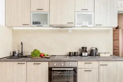 a kitchen with white cabinets and a counter with fruits and vegetables at Apartment Petar 1 in Kotor
