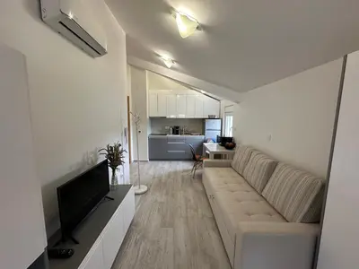 a living room with a couch and a television at Studio Lemar in Budva
