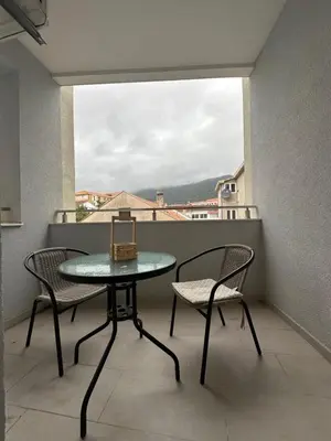 a table and two chairs on a balcony with a window at Studio Lemar in Budva