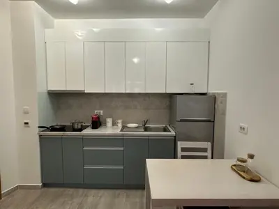 a kitchen with white cabinets and a stainless steel refrigerator at Studio Lemar in Budva