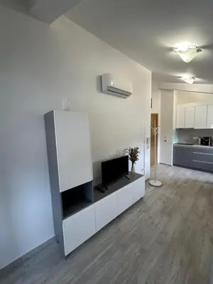 a living room with a tv on a white cabinet at Studio Lemar in Budva