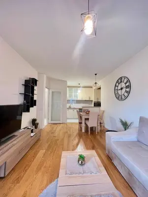 a living room with a white couch and a table at White Homes - Central Point in Podgorica