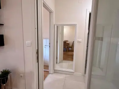 a hallway with a mirror and a door to a room at White Homes - Central Point in Podgorica