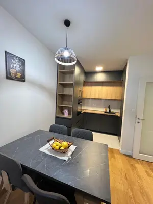 a kitchen with a table with a bowl of fruit on it at White Homes - Central Point in Podgorica