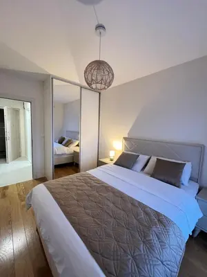a bedroom with a large bed and a large mirror at White Homes - Central Point in Podgorica