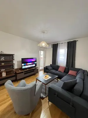 a living room with a couch and chairs and a tv at White Homes - Central Point in Podgorica