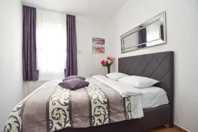 a bedroom with a bed with a purple pillow on it at Stan Stari Grad Budva in Budva