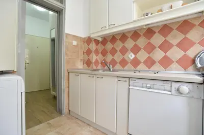 a kitchen with white cabinets and a sink at Stan Stari Grad Budva in Budva