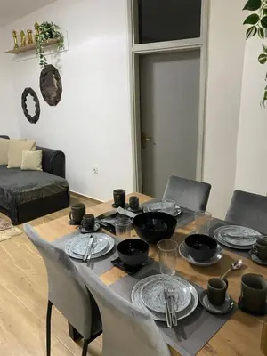 a table with plates and bowls on it in a living room at Stan Stari Grad Budva in Budva