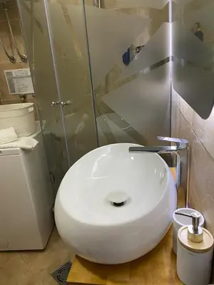 a white toilet in a bathroom with a glass shower at Stan Stari Grad Budva in Budva