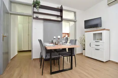 a dining room with a table and chairs and a tv at Stan Stari Grad Budva in Budva