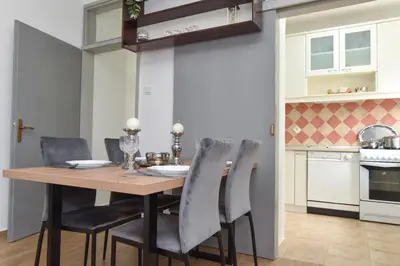 a kitchen and dining room with a wooden table and chairs at Stan Stari Grad Budva in Budva
