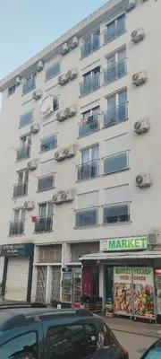 a white building with cars parked in front of it at Stan-apartman, Apartment, квартира in Bar