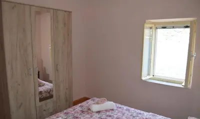 a bedroom with two beds and a window and a mirror at Iva apartment in Kotor
