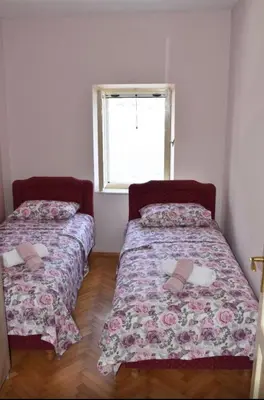 two beds in a small room with a window at Iva apartment in Kotor