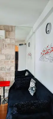 a bedroom with a black bed and a brick wall at Apartment Pržno in Pržno
