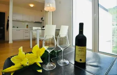 a bottle of wine and two glasses on a table at Apartment Pržno in Pržno