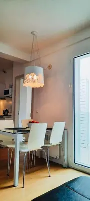 a dining room table with white chairs and a chandelier at Apartment Pržno in Pržno