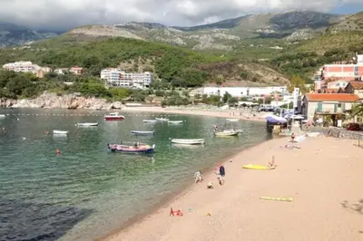 a group of people on a beach with boats in the water at Apartment Pržno in Pržno