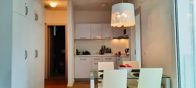 a kitchen with a glass table and white cabinets at Apartment Pržno in Pržno