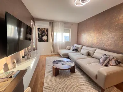 a living room with a couch and a flat screen tv at White Homes 105 - Central Point in Podgorica