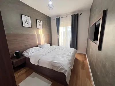 a bedroom with a bed and a television in it at White Homes 105 - Central Point in Podgorica