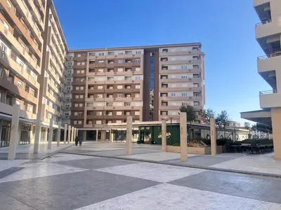 a person walking in front of a tall building at White Homes 105 - Central Point in Podgorica