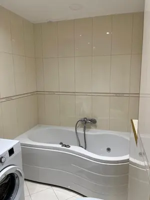 a bath tub in a bathroom with a washing machine at Blue lagoon apartment Przno in Budva