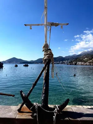 a wooden boat with a rope on a body of water at Blue lagoon apartment Przno in Budva