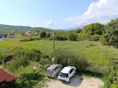 two cars parked in a field next to a house at Green Valley GV in Kotor
