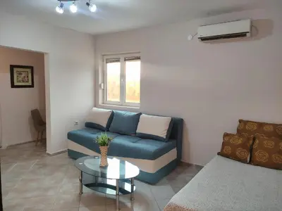 a living room with a blue couch and a table at Green Valley GV in Kotor