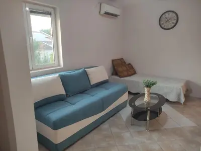 a living room with a blue couch and a table at Green Valley GV in Kotor