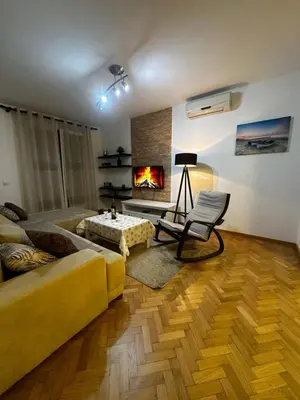 a living room with a yellow couch and a fireplace at City apartment with the sea view in Bar