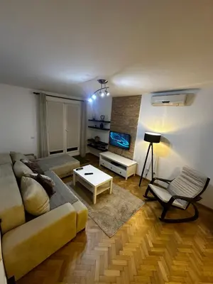 a living room with a couch and a tv at City apartment with the sea view in Bar