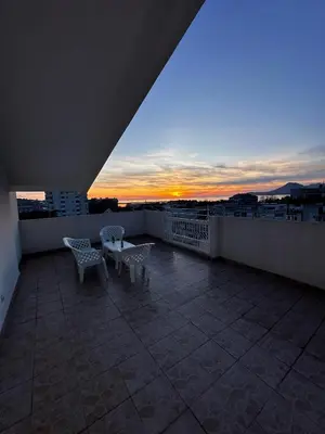 a balcony with a table and chairs on a roof at City apartment with the sea view in Bar