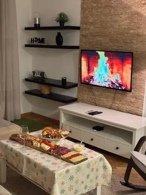 a living room with a table and a tv at City apartment with the sea view in Bar