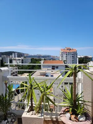 a view of a city from a balcony with palm trees at City apartment with the sea view in Bar