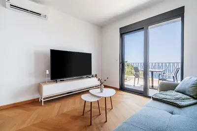 a living room with a tv and a couch and a table at Monte Living by In Property in Ðenaši
