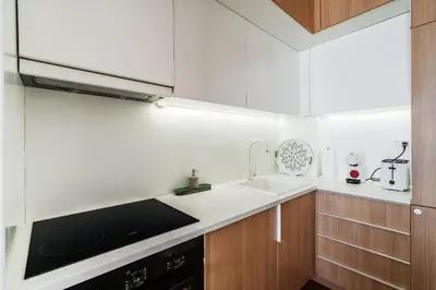a white kitchen with a sink and a stove at Monte Living by In Property in Ðenaši