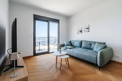 a living room with a blue couch and a table at Monte Living by In Property in Ðenaši