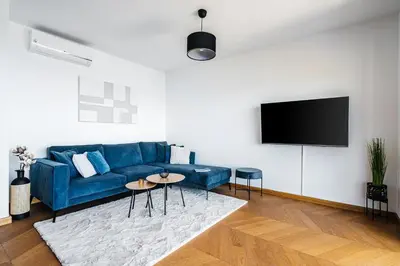 a living room with a blue couch and a flat screen tv at Monte Living by In Property in Ðenaši